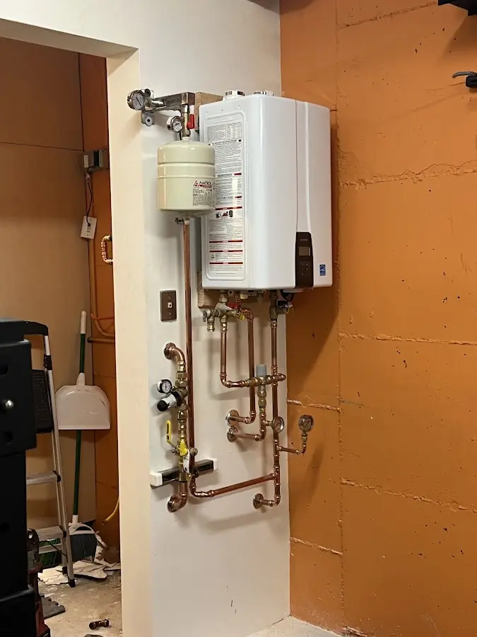 Plumbing technician inspecting water heater connections in West Falls Church
